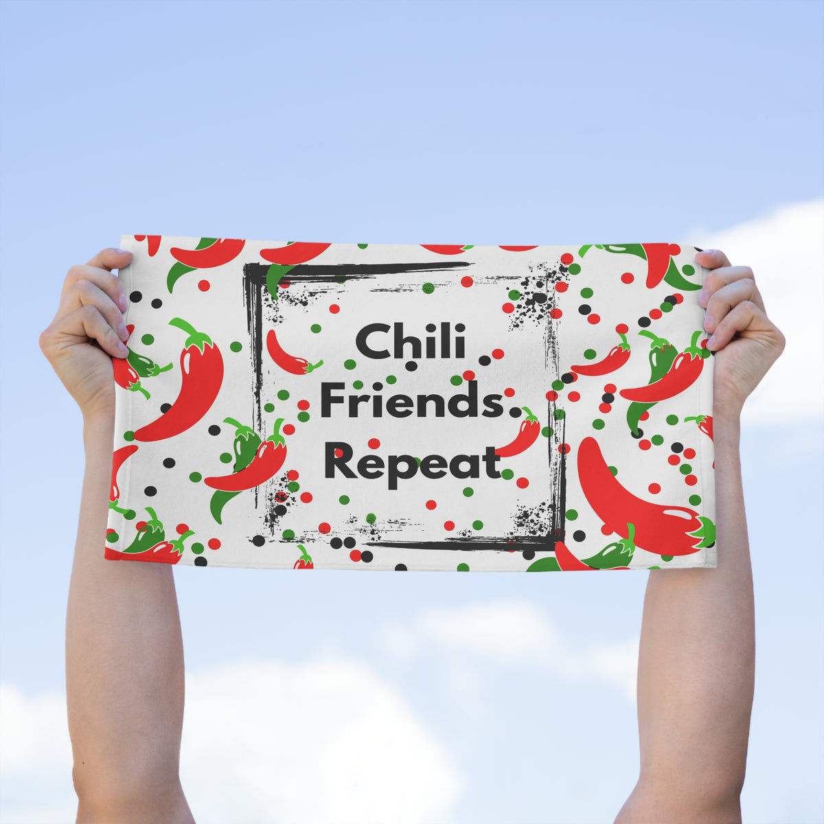 Chili Friends Repeat kitchen towel held horizontally showing red chili pepper pattern