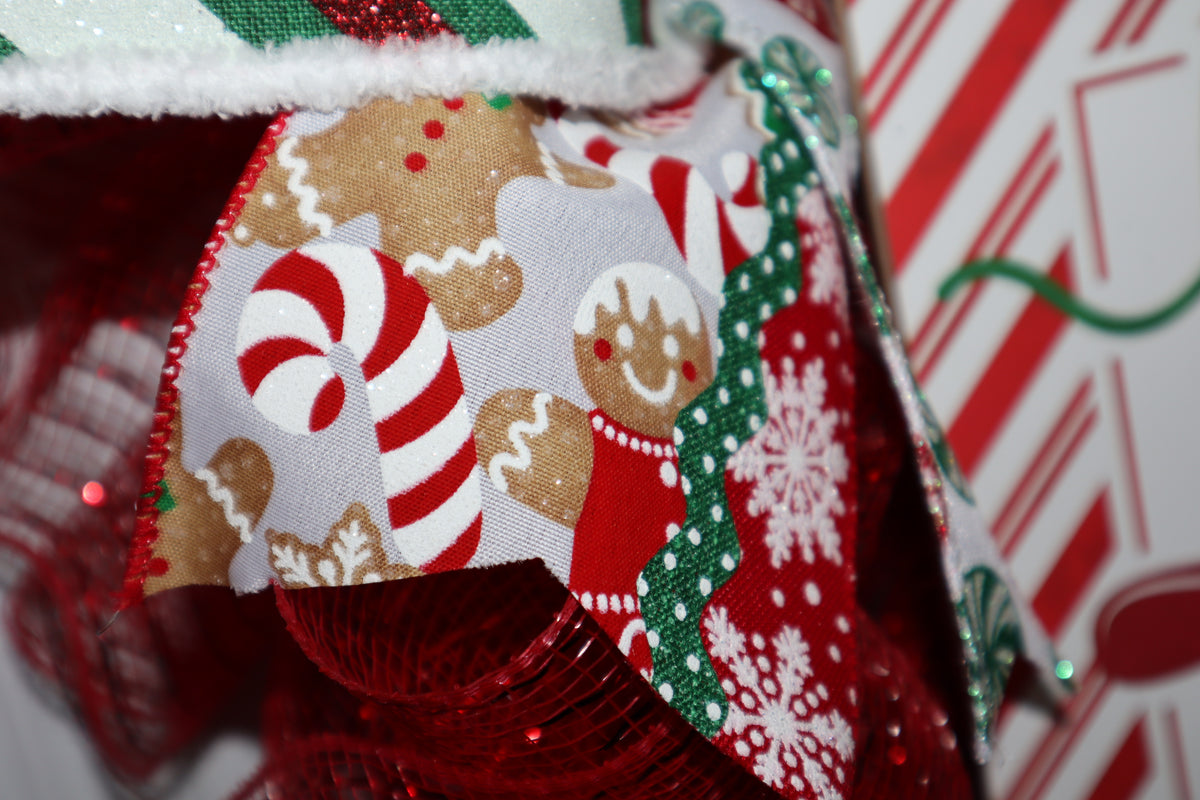 Close-up of gingerbread and peppermint wired ribbon on red Christmas wreath