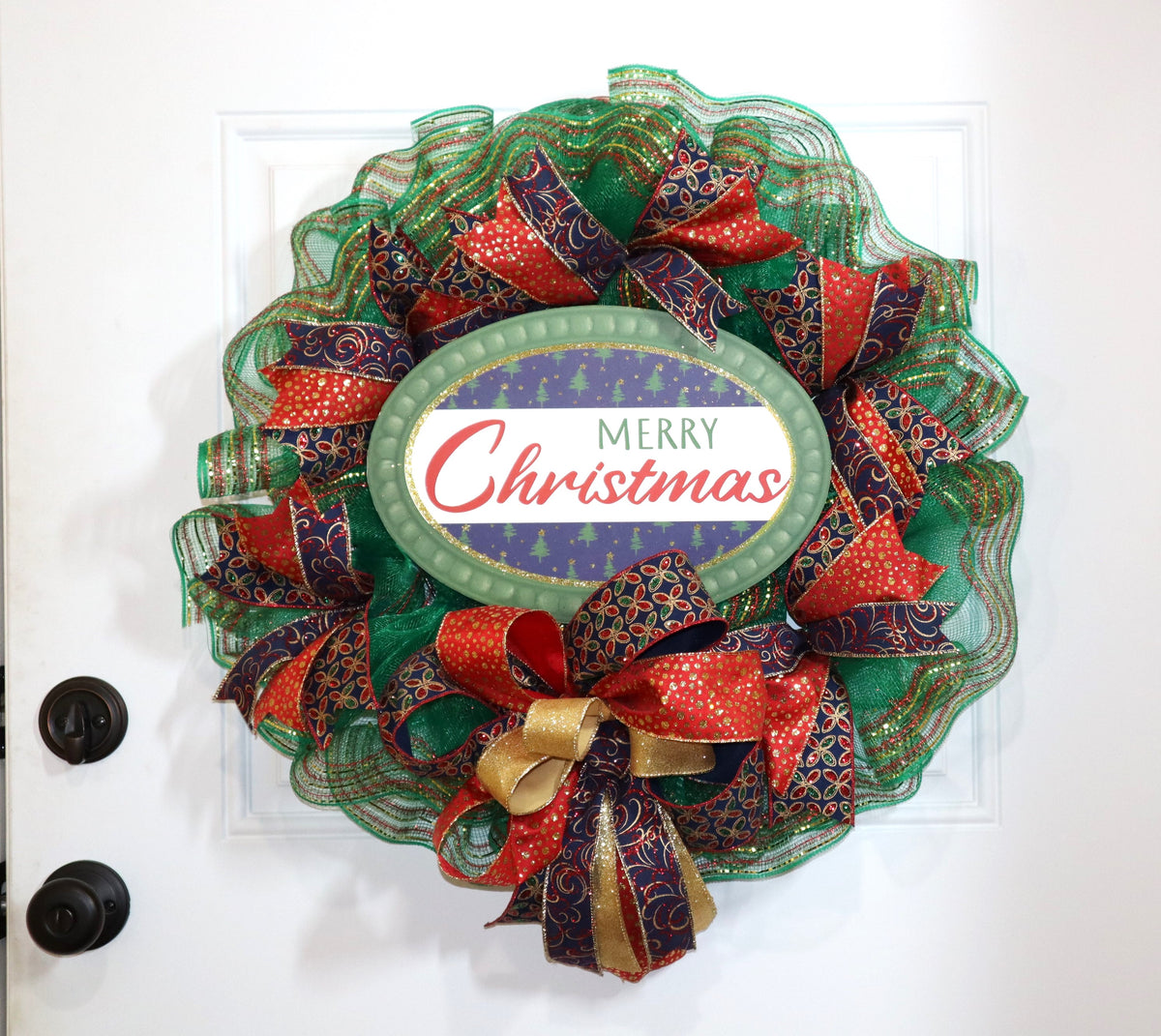 Handmade Merry Christmas wreath displayed on white front door