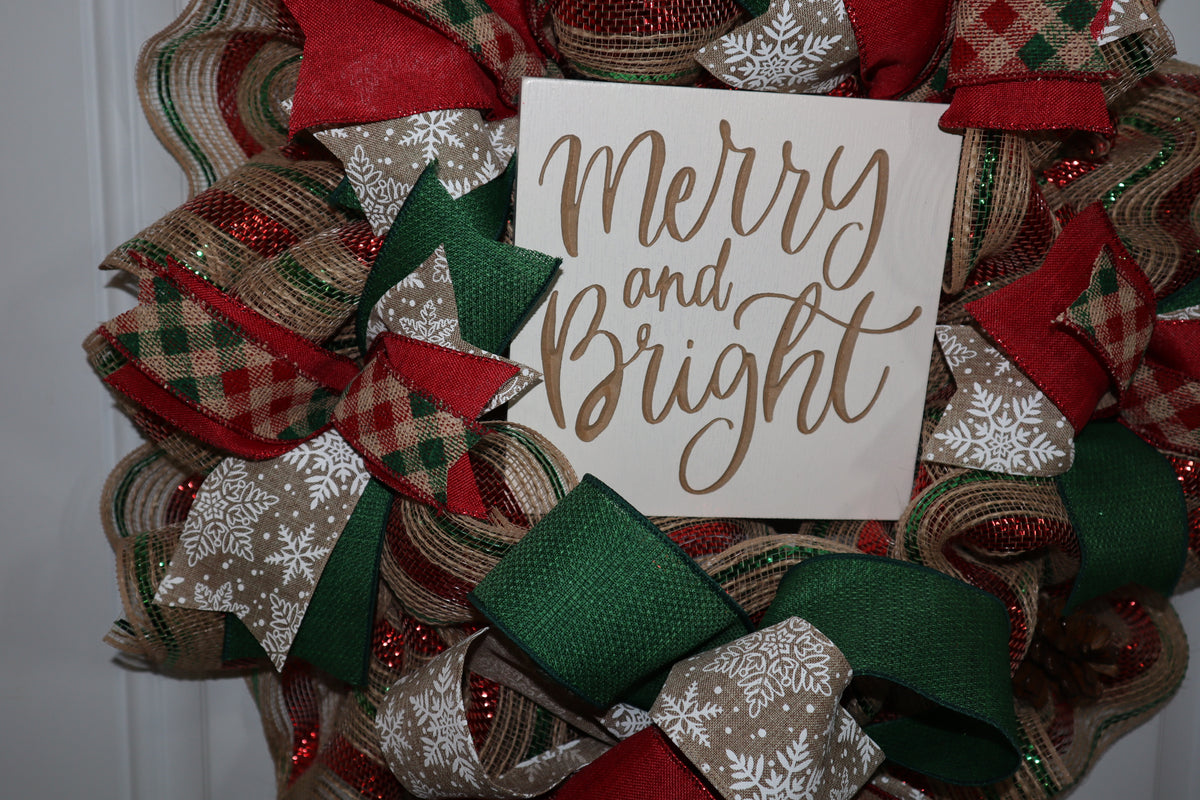 Close-up of Merry and Bright wood sign with Christmas ribbon and deco mesh