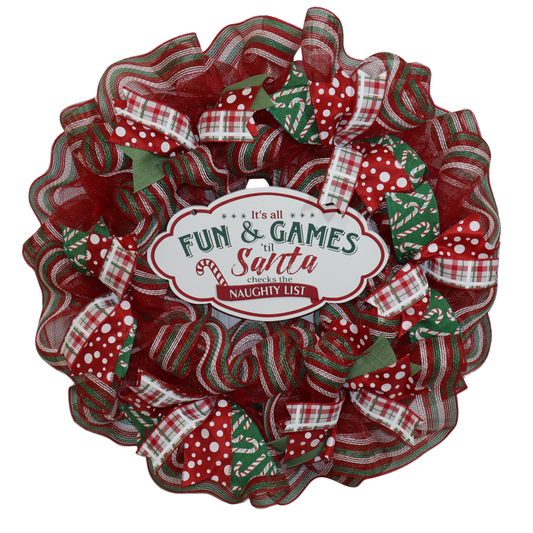 Handmade red and green Christmas mesh wreath with festive ribbon and center sign
