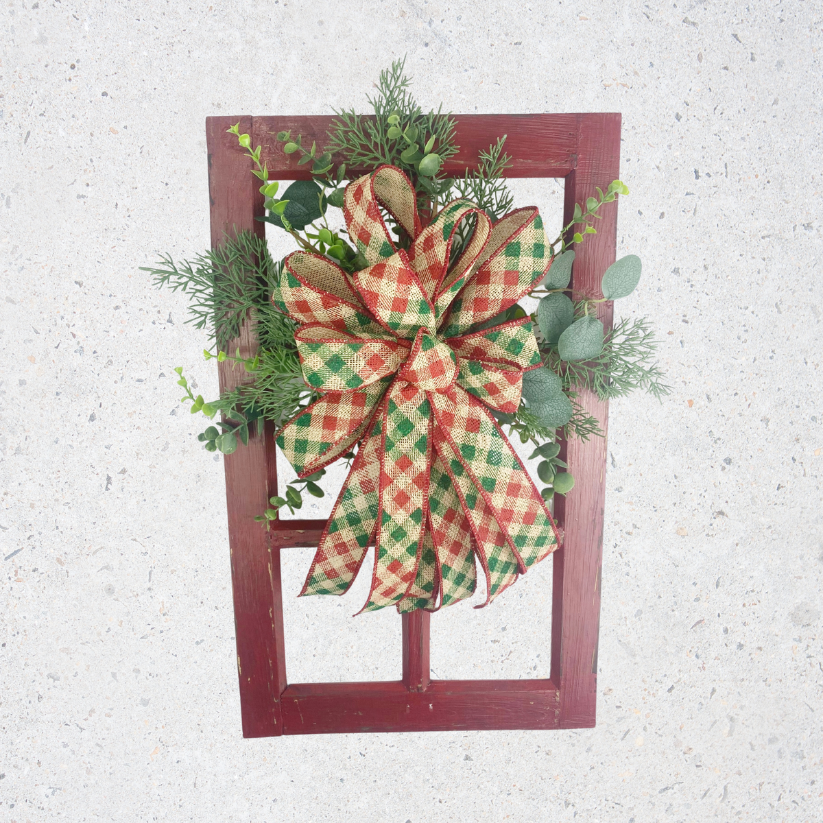 Rustic Christmas window frame door hanger with red and green plaid bow, evergreen greenery, and distressed red wood frame.