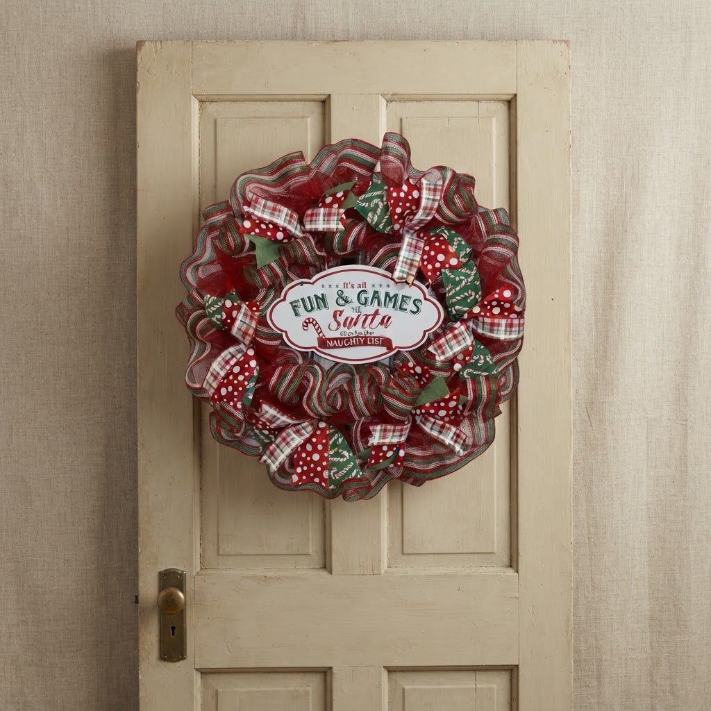 Red and green handmade Christmas wreath on neutral vintage door