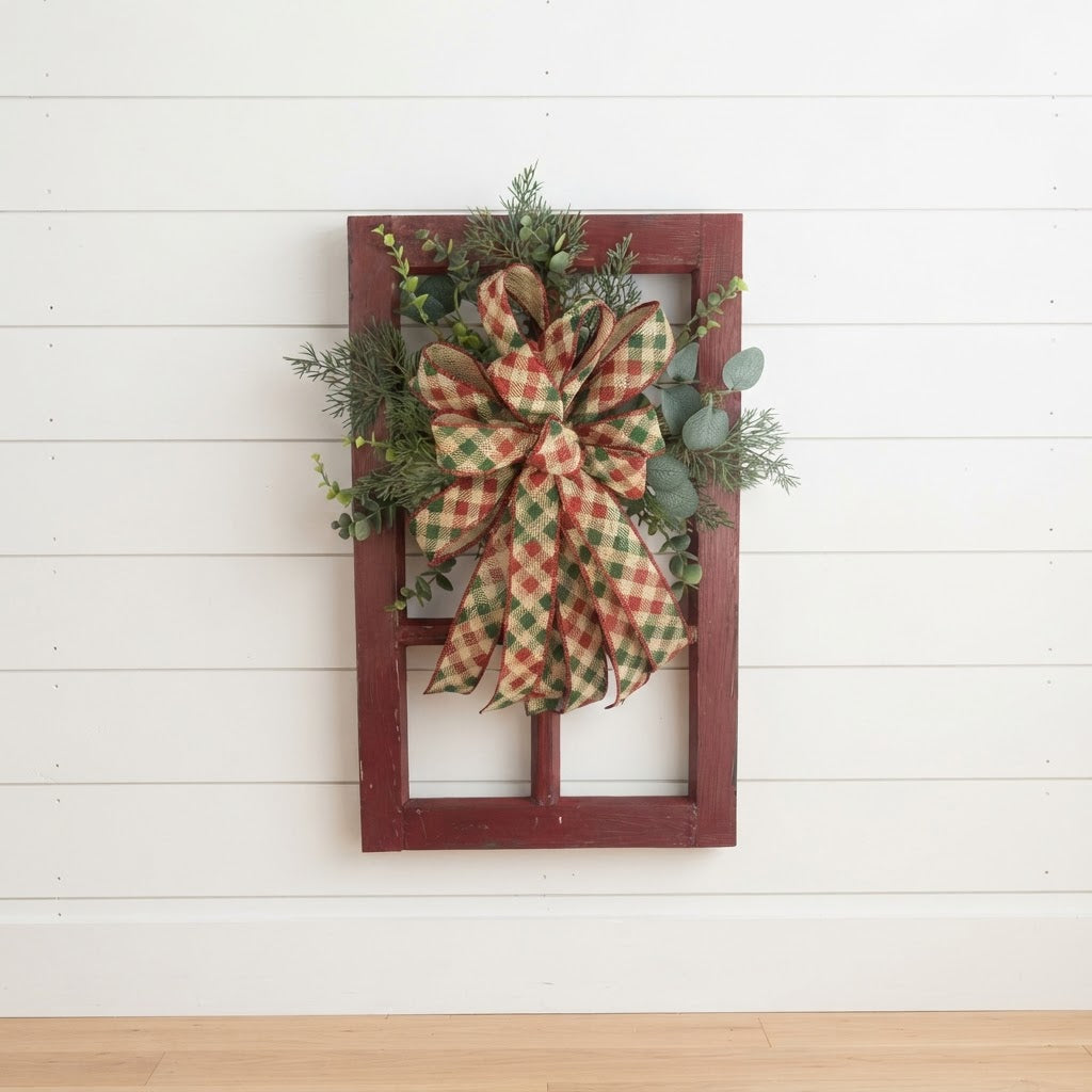 Christmas window frame wall decor with plaid designer bow and evergreen greenery displayed on white shiplap.