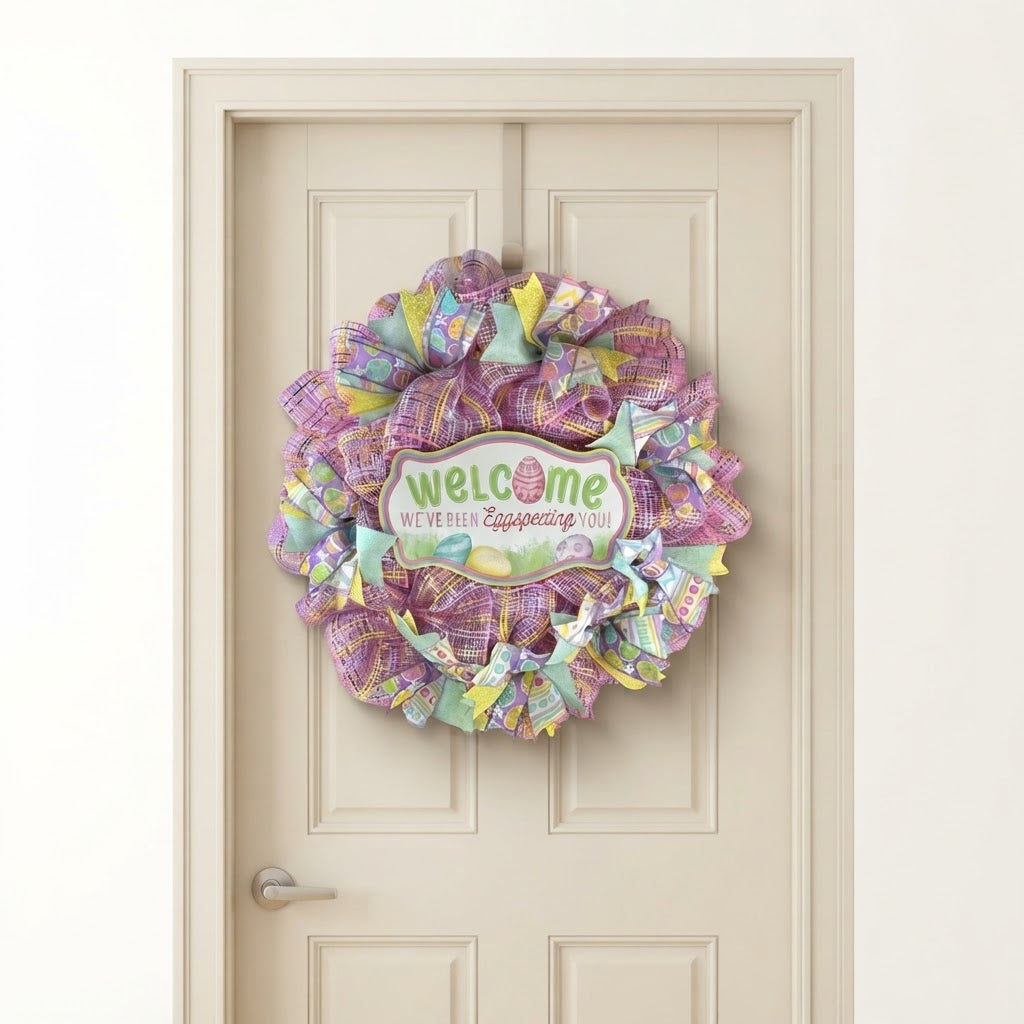 Handmade Easter wreath with pastel ribbons and pink mesh displayed on a  wood door
