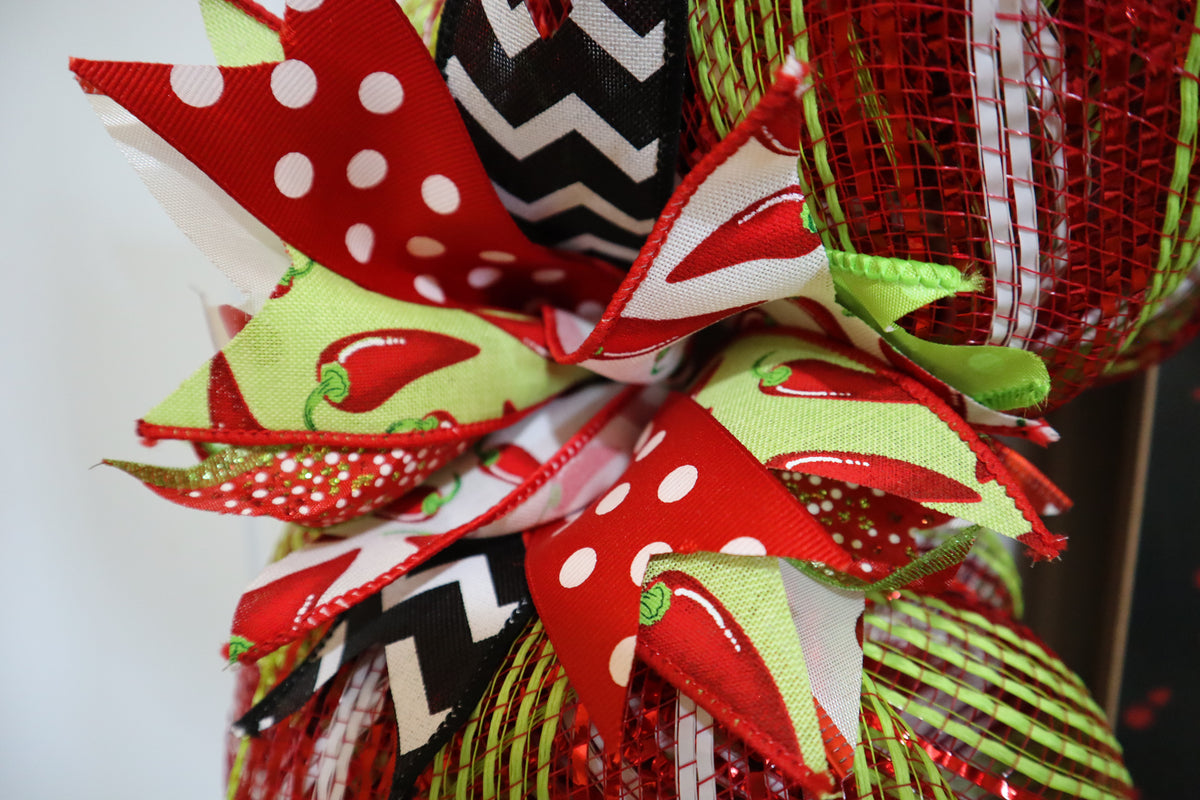 Close-up of chili pepper ribbon, polka dot ribbon and deco mesh on handmade wreath
