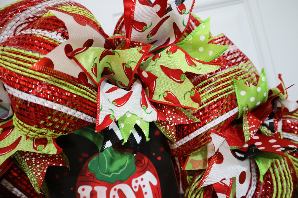 Close-up of layered wired ribbons and red lime green deco mesh on chili wreath
