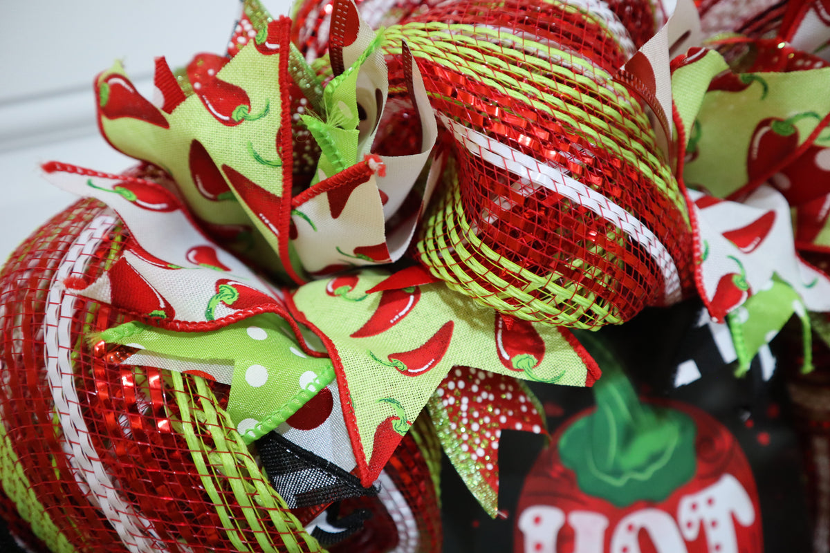 Detailed view of chili pepper ribbon and decorative mesh on wreath
