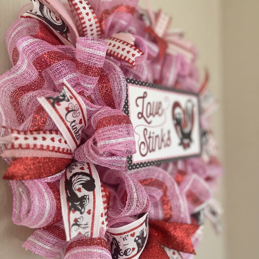 Side view showing the depth and ribbon details of the Love Stinks wreath.