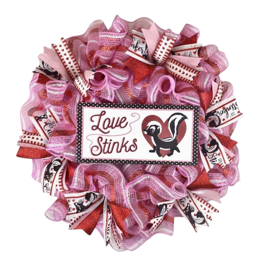Love Stinks Valentine's Day mesh wreath with pink and red ribbon on white background.