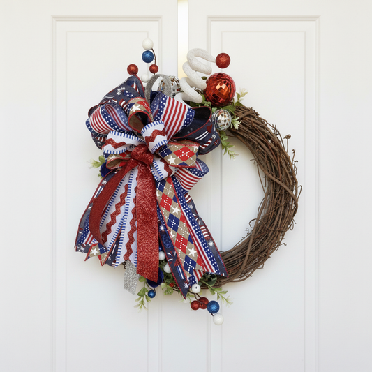 Handmade patriotic grapevine wreath with red, white and blue ribbon on a white front door