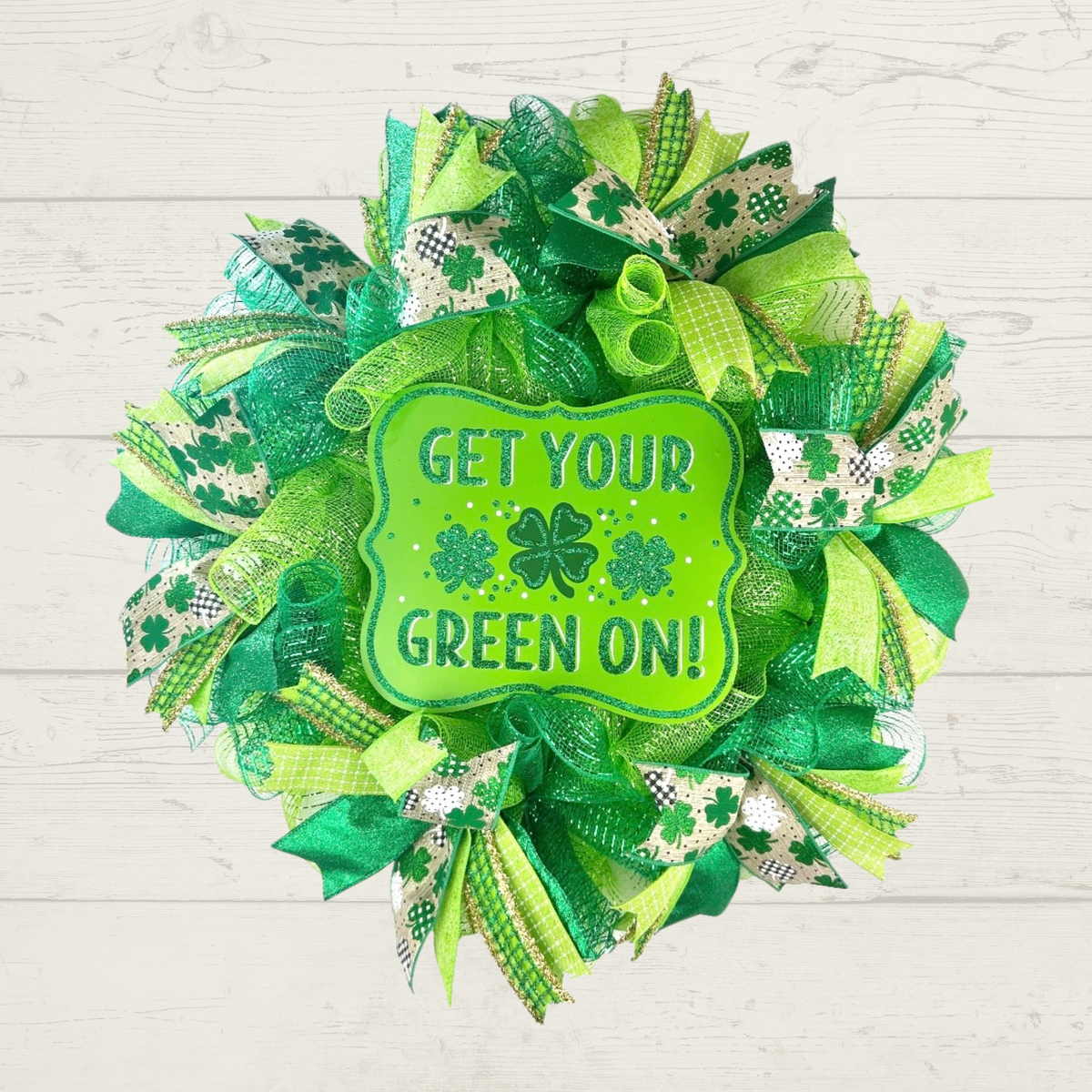 St. Patrick's Day shamrock wreath displayed on white wood background