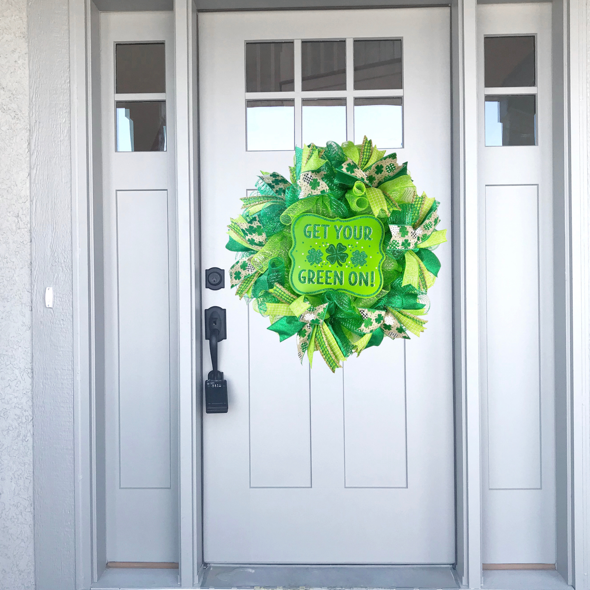 Shamrock mesh wreath displayed on a white front door