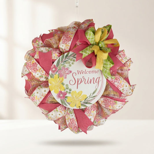 Handmade Welcome Spring floral mesh wreath with pink, yellow, and green ribbons on a white background.