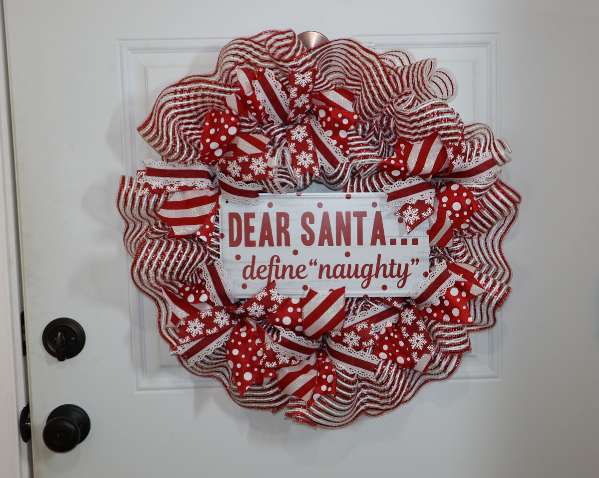Handmade red and white Christmas mesh wreath displayed on white door
